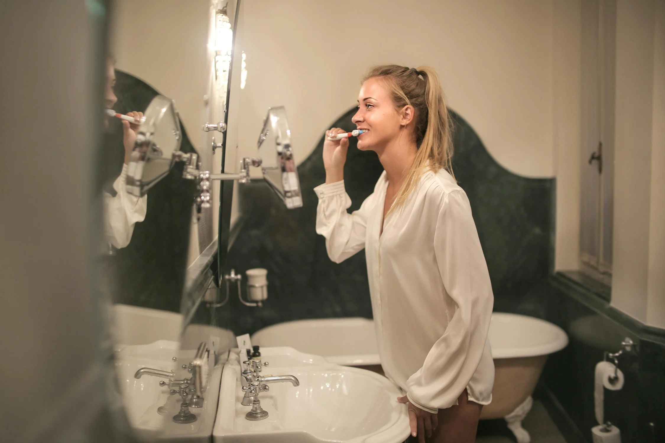 Daily Oral Care at Home – Where Natural Wellness Begins A woman brushing her teeth at home, reflecting Grin Teeth’s mission to promote simple, effective oral care routines for healthier habits and confident smiles.