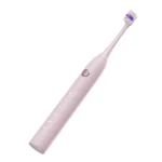 Angled top view of Grin Teeth ET 3A minimalist electric toothbrush in soft pink, highlighting control button and mode icons