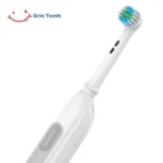 Grin Teeth ET 6B electric rotating toothbrush close-up showing quiet round brush head and textured power button