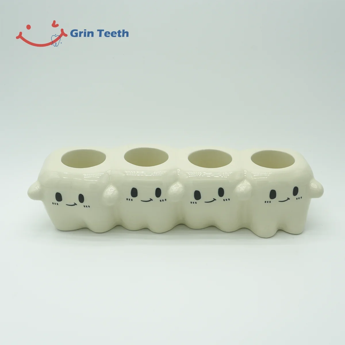 Close-up of four-slot cute tooth-shaped ceramic electric toothbrush holder