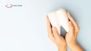 Hands gently holding a large model of a tooth to symbolize oral health