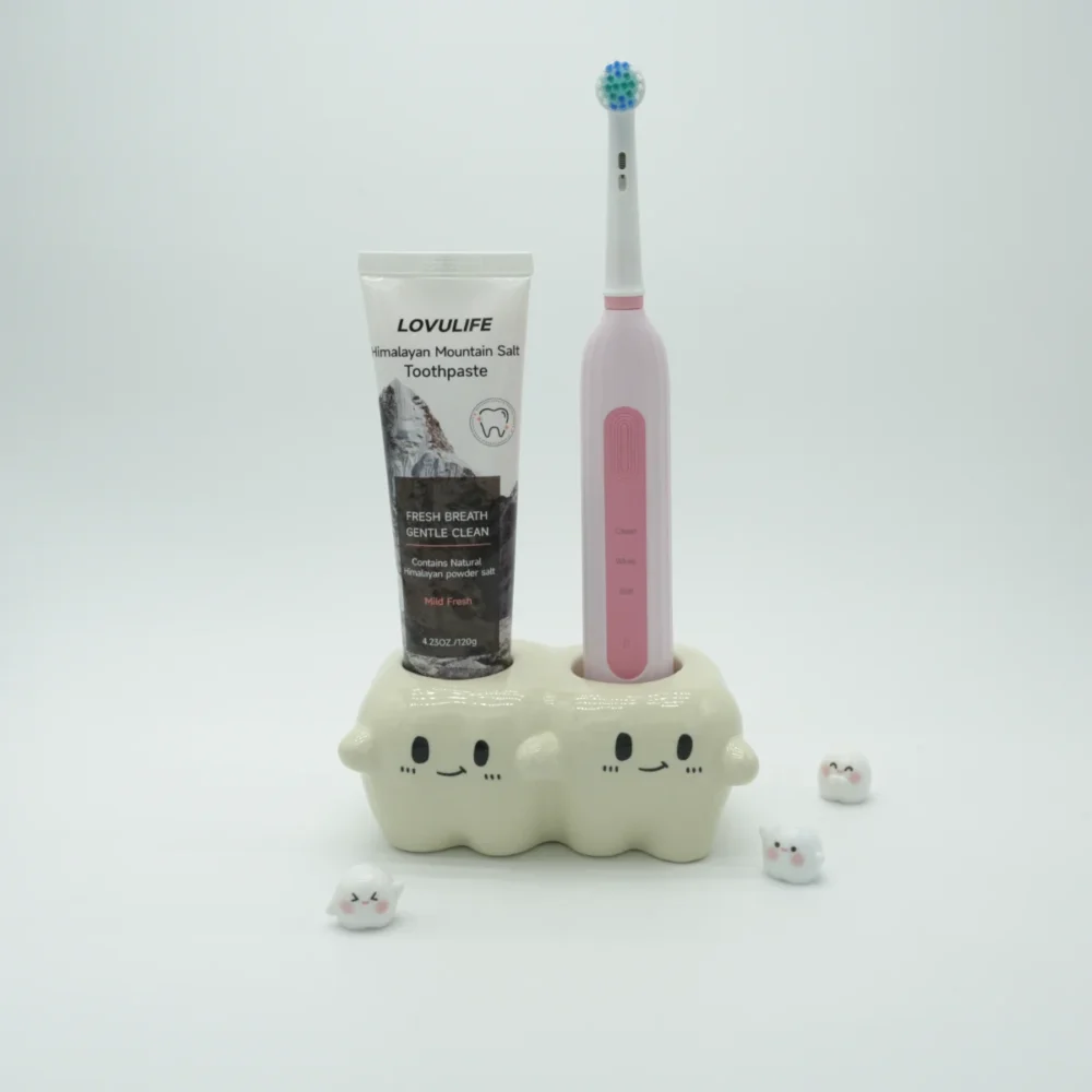Ceramic tooth-inspired toothbrush holder holding one electric toothbrush and a tube of toothpaste