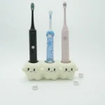 Ceramic tooth-inspired electric toothbrush holder organizing 3 colorful electric toothbrushes